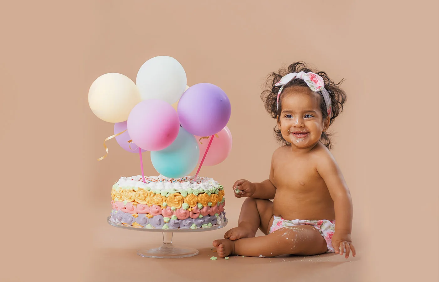 Kleinkind mit Geburtstagstorte und Luftballons beim Cake-Smash-Shooting